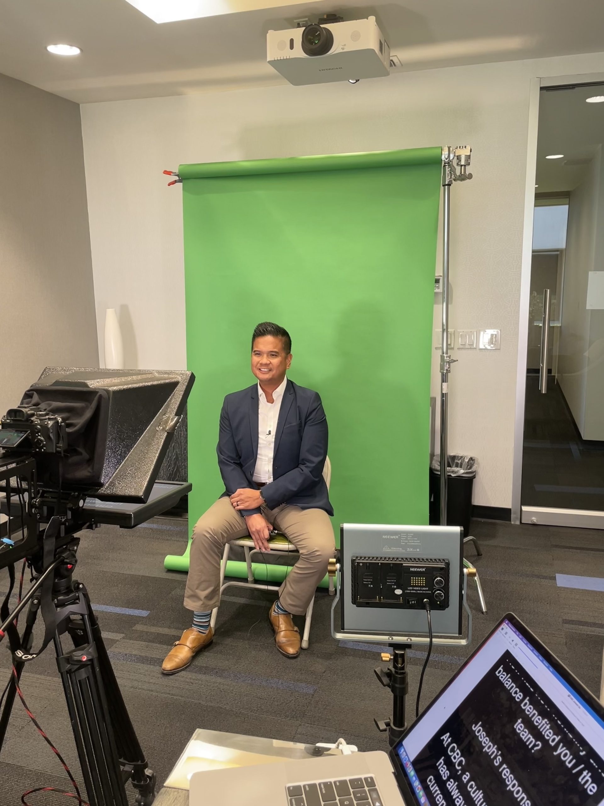 client waits in front of a green screen with a teleprompter for video marketing campaign